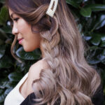 Profile of a woman with long wavy hair and a braid.